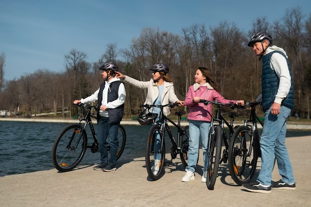 Four young individuals each holding their own bicycles