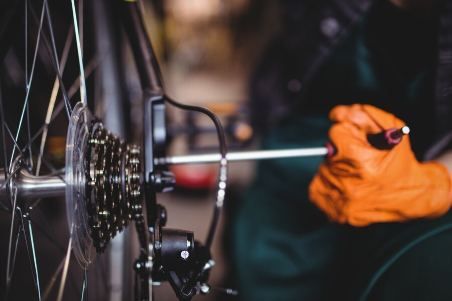An image of a hand with gloves operating a bicycle camera focused on the chain