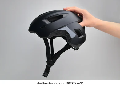Hand holding black helmet from above