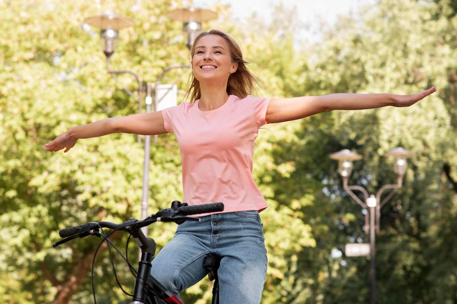 Teenager riding a bike with arms outstretched