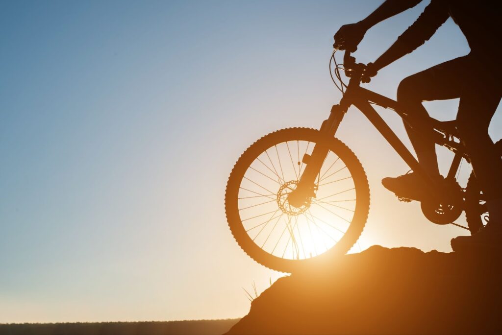 Man is cycling mountain on the sunset